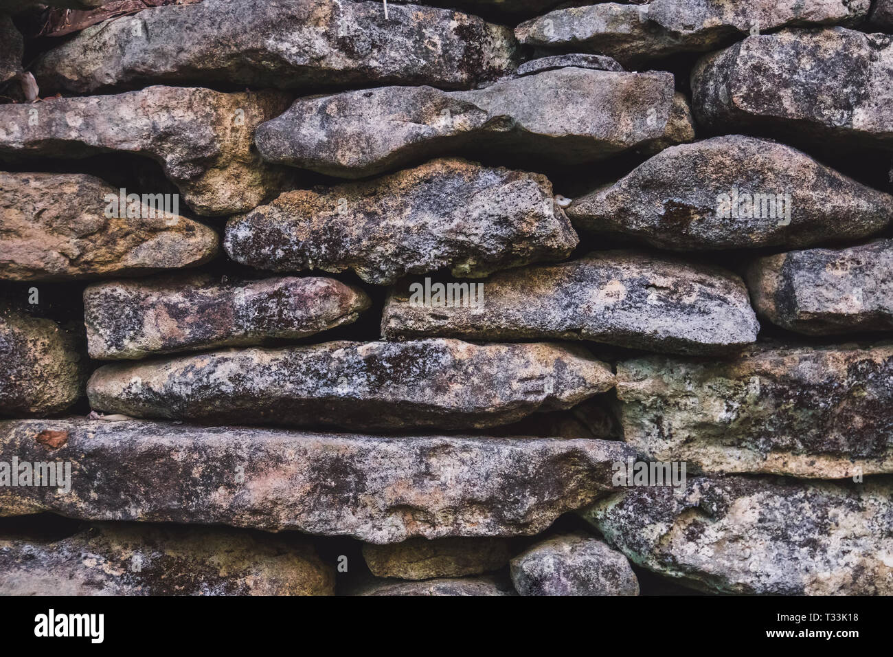 Vieux Mur de pierre. la texture de la pierre couverts de mousse Banque D'Images