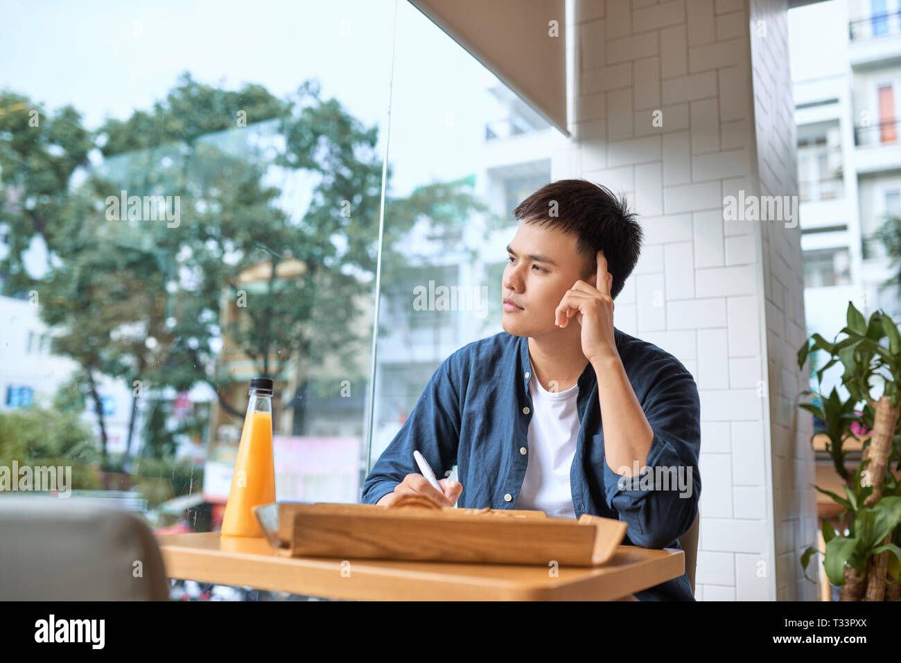 Beau mâle qualifiés rédacteur en chef Revue de script de lecture jeune auteur corriger les erreurs dans l'ordinateur portable tout en buvant du café pour le petit-déjeuner au cours de br Banque D'Images