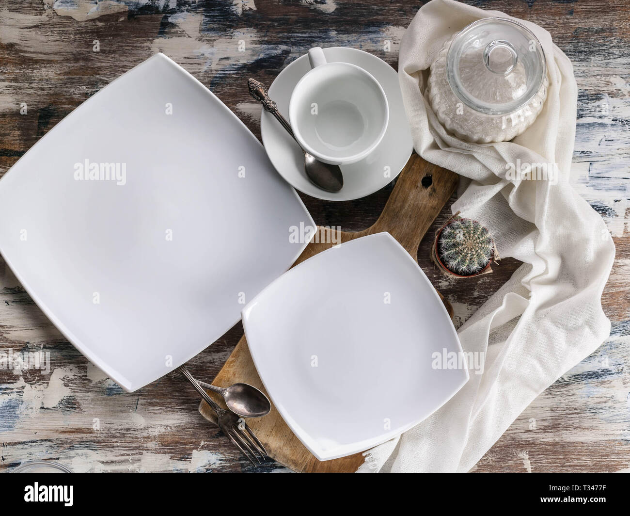 Carré blanc vide assiettes et bols. Ensemble de vaisselle blanche sur une  table rustique en bois. Vue d'en haut Photo Stock - Alamy