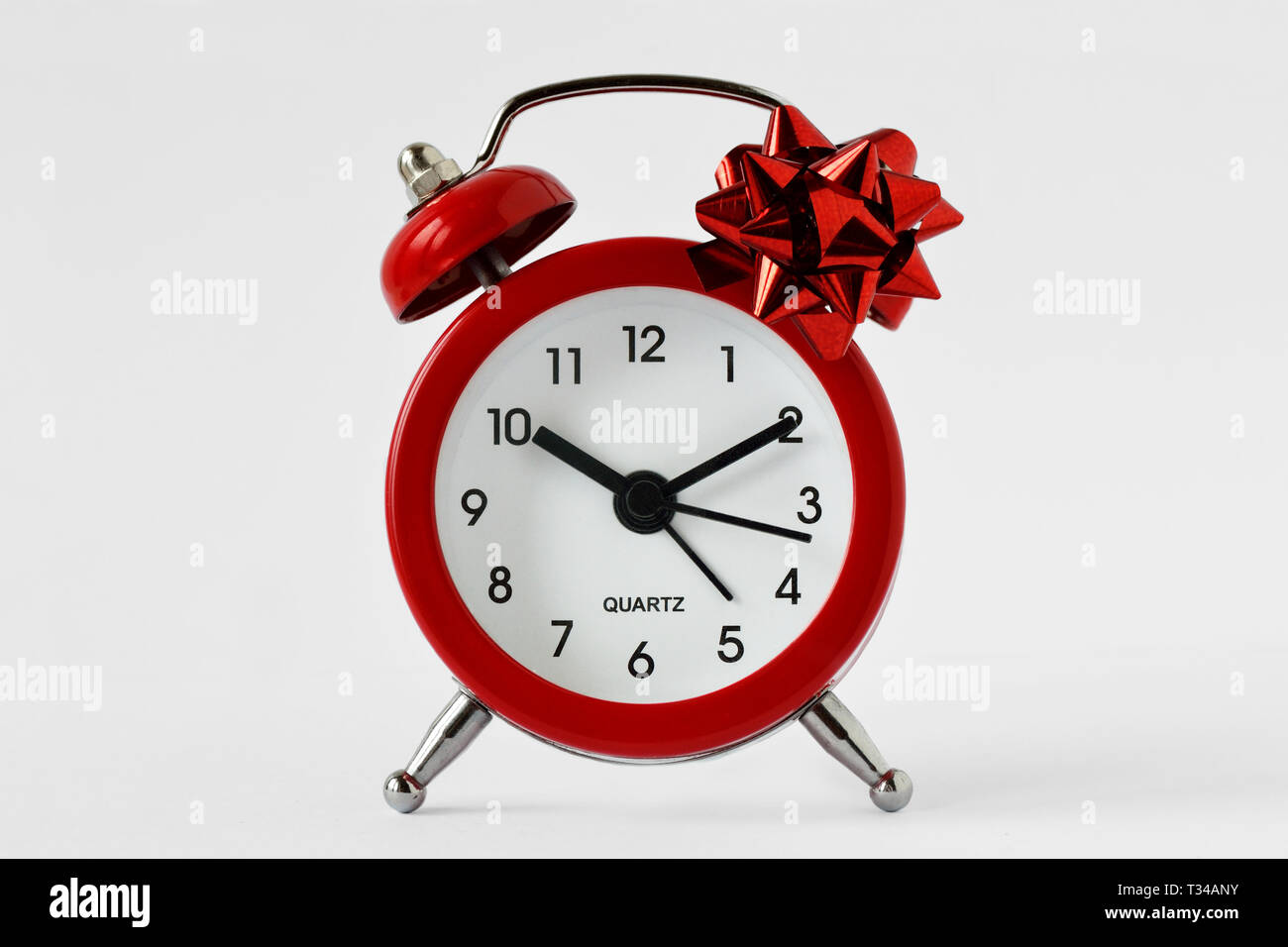Réveil rouge cadeau avec noeud sur fond blanc - Le don du temps ; temps pour concept concept cadeaux Banque D'Images