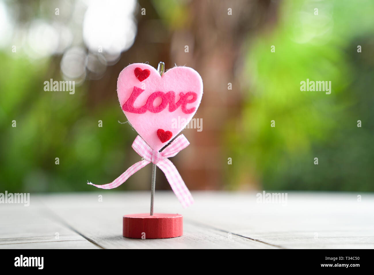 Love concept : forme de Cœur sur un support à mot amour et sur un jardin ou sur fond vert Banque D'Images