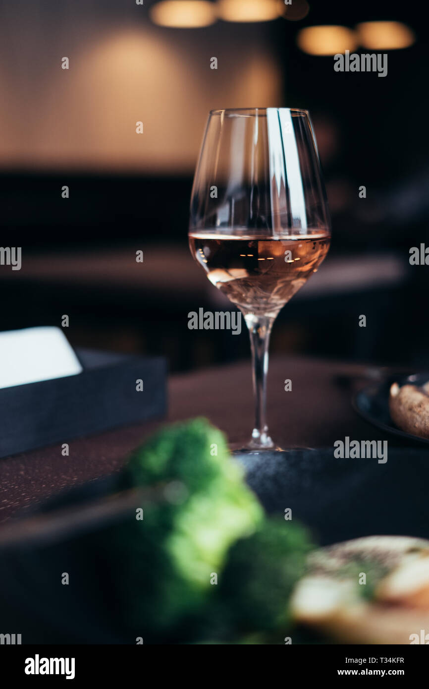 Verre de vin rose sur une table à dîner Banque D'Images