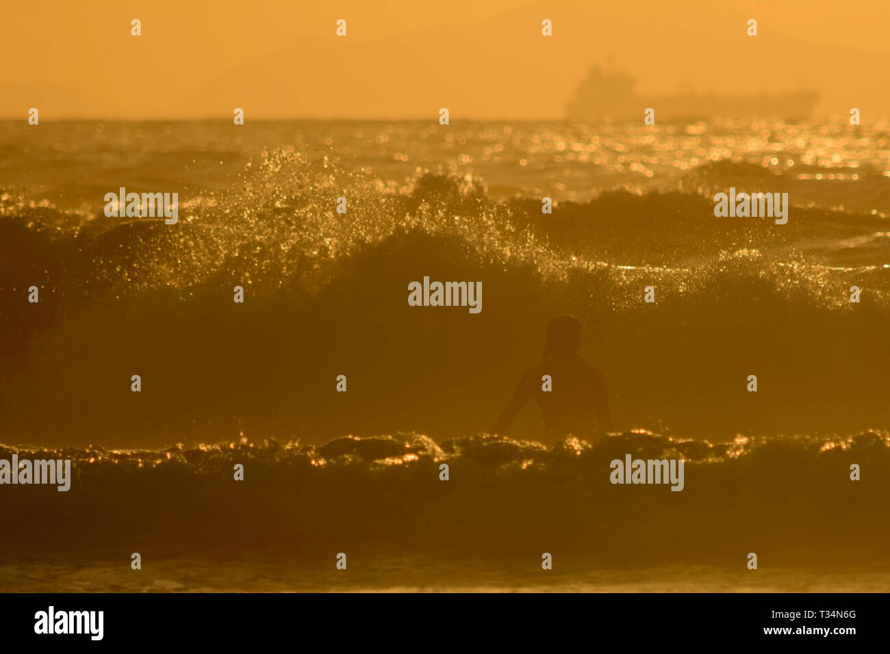 Silhouette d'un surfeur attraper une vague au coucher du soleil, plage de Sopelana, Biscaye, Espagne Banque D'Images