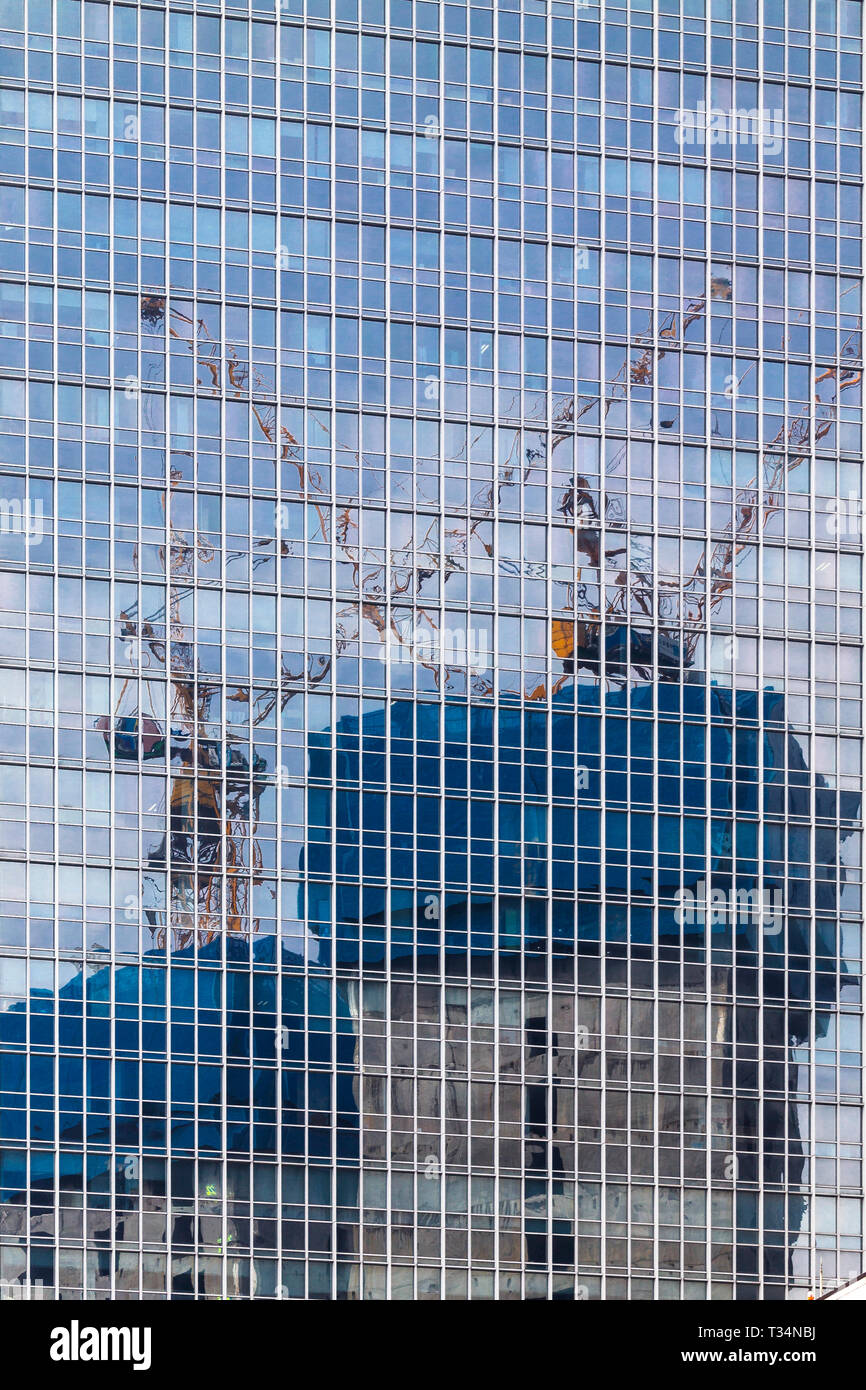 La réflexion de grues dans un gratte-ciel moderne, Jakarta, Indonésie Banque D'Images