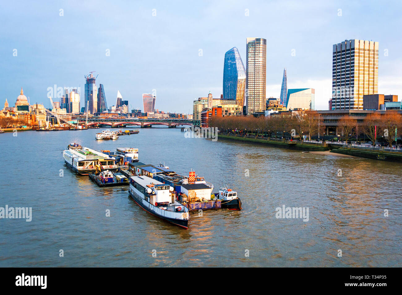 Cityscape et bateaux sur la Tamise au crépuscule, Londres, Angleterre, Royaume-Uni Banque D'Images