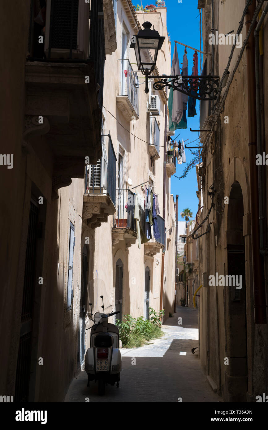 Motorscooter, d'un balcon, d'une lanterne et de blanchisserie en scène de rue à ruelle en grec de rues par la via della Giudecca, Ortigia, Syracuse, Sicile Banque D'Images