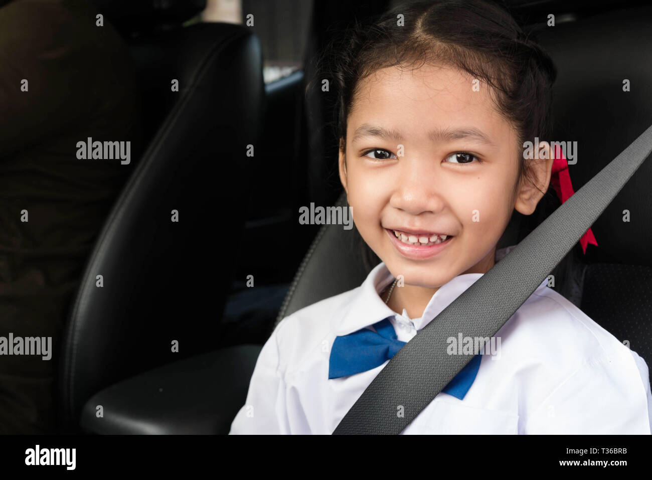Asian girl porter l'uniforme scolaire s'asseoir dans la voiture et attacher  la ceinture de sécurité. Les étudiants assis avec les parents Photo Stock -  Alamy