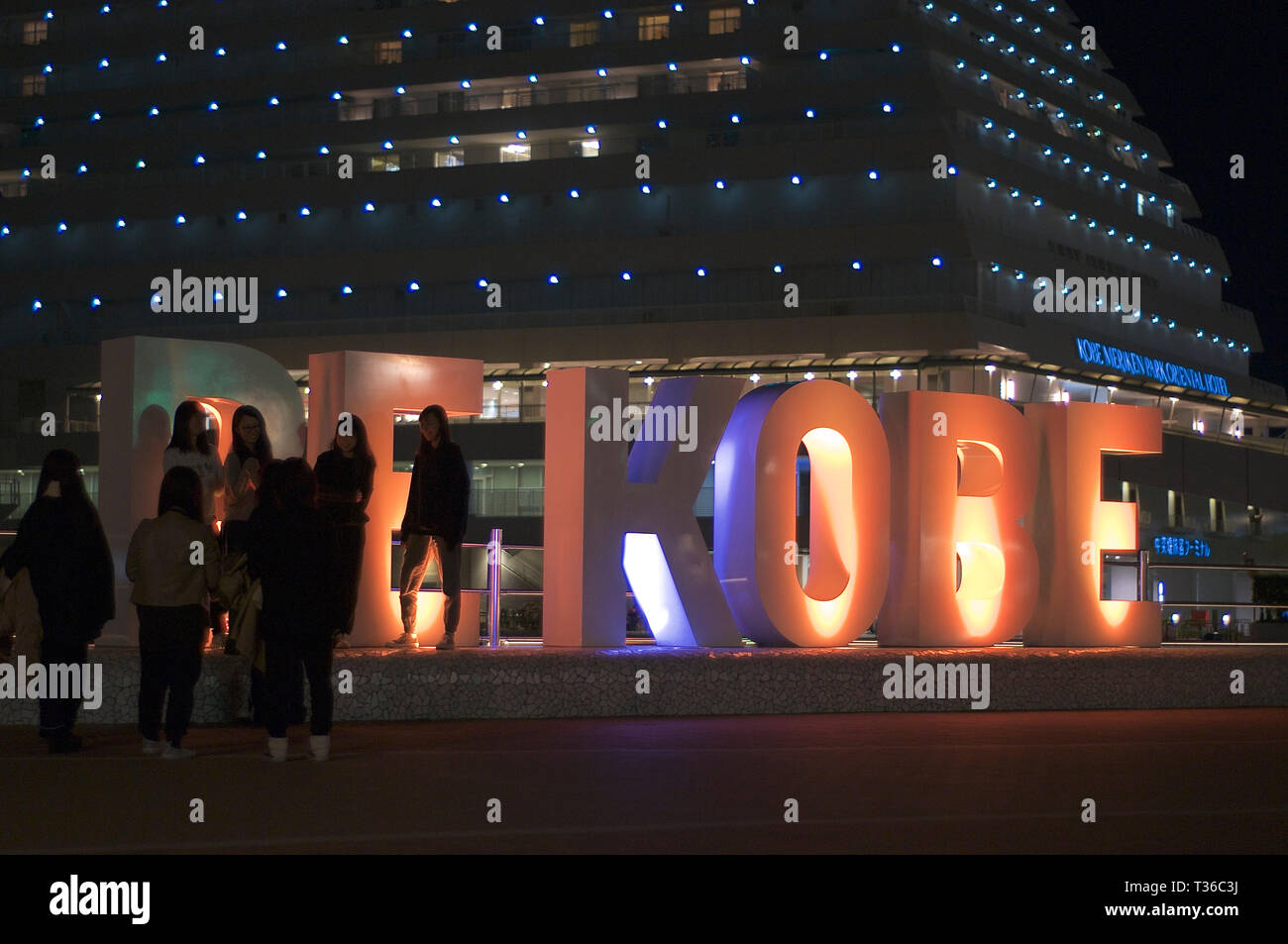 Kobe, Hyogo, Japon - 16 novembre 2018 : Photo de quelques personnes debout en face de l'éclairage d'être 'KOBE' monument avec le Kobe Meriken Park Ho Banque D'Images