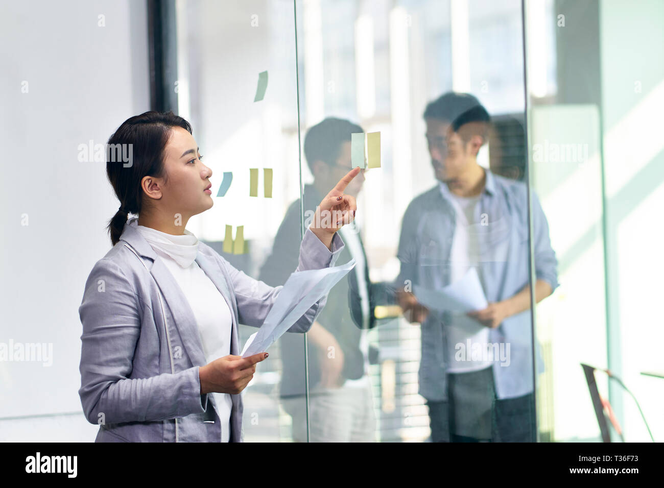 Young Asian business woman et les hommes qui travaillent dans le bureau. Banque D'Images