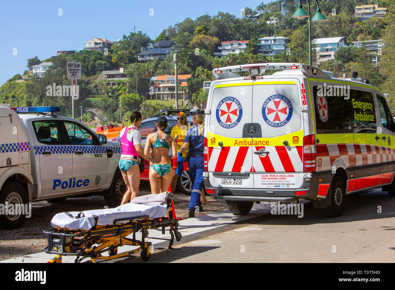 Ambulances et paramédics de Sydney avec brancard prêt pour une quasi-noyade victime en cours au large de la plage, Sydney, Australie Banque D'Images