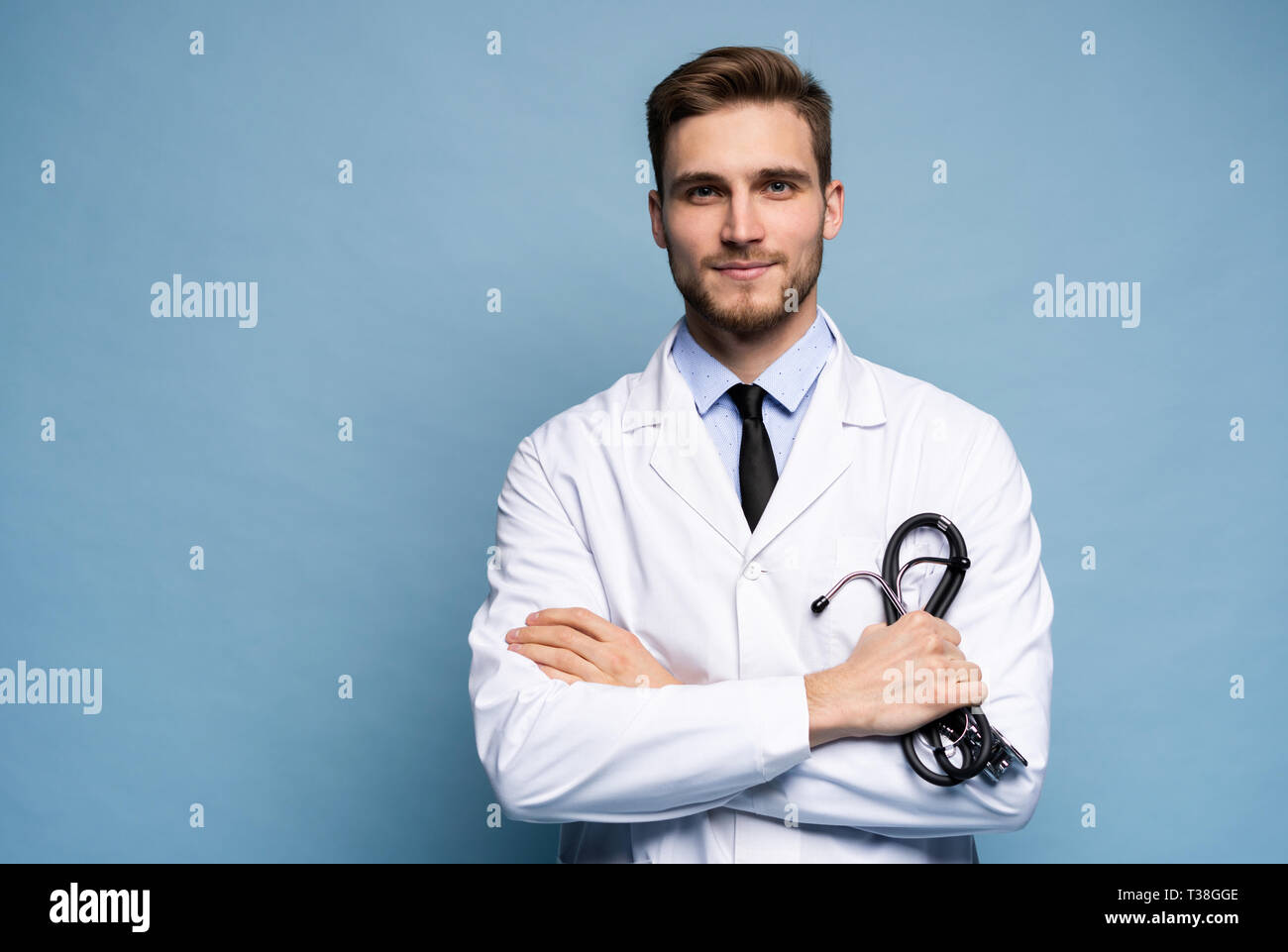 Portrait of jeune médecin sur fond bleu. Banque D'Images