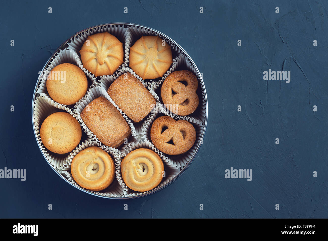 Les cookies dans une boite métal sur un fond bleu foncé. Close-up. Macro  Photo Stock - Alamy