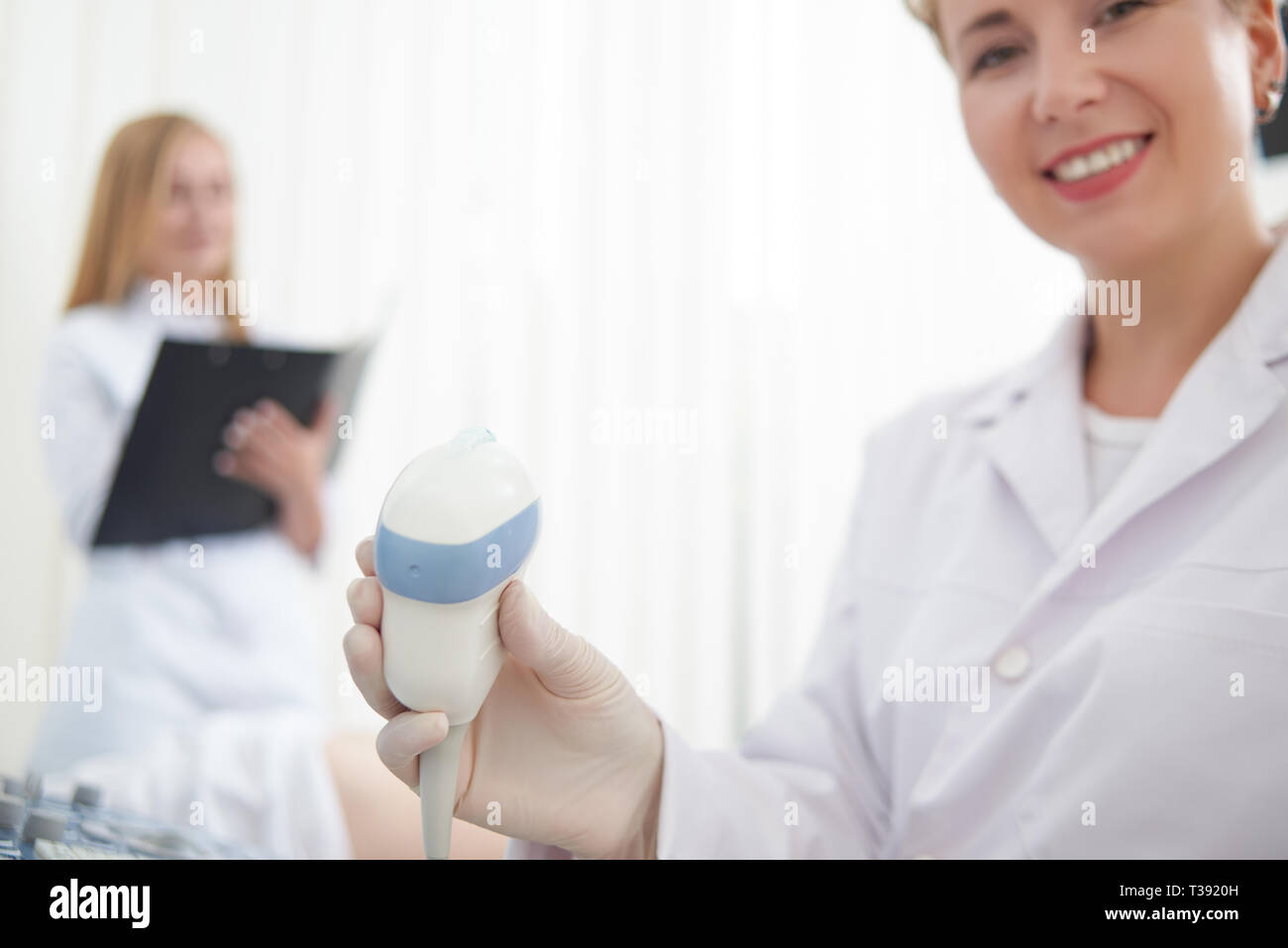Close up de dispositif médical spécial pour le diagnostic échographique. Female doctor smiling at camera, et outil de maintien pour examen. Assistant en Banque D'Images