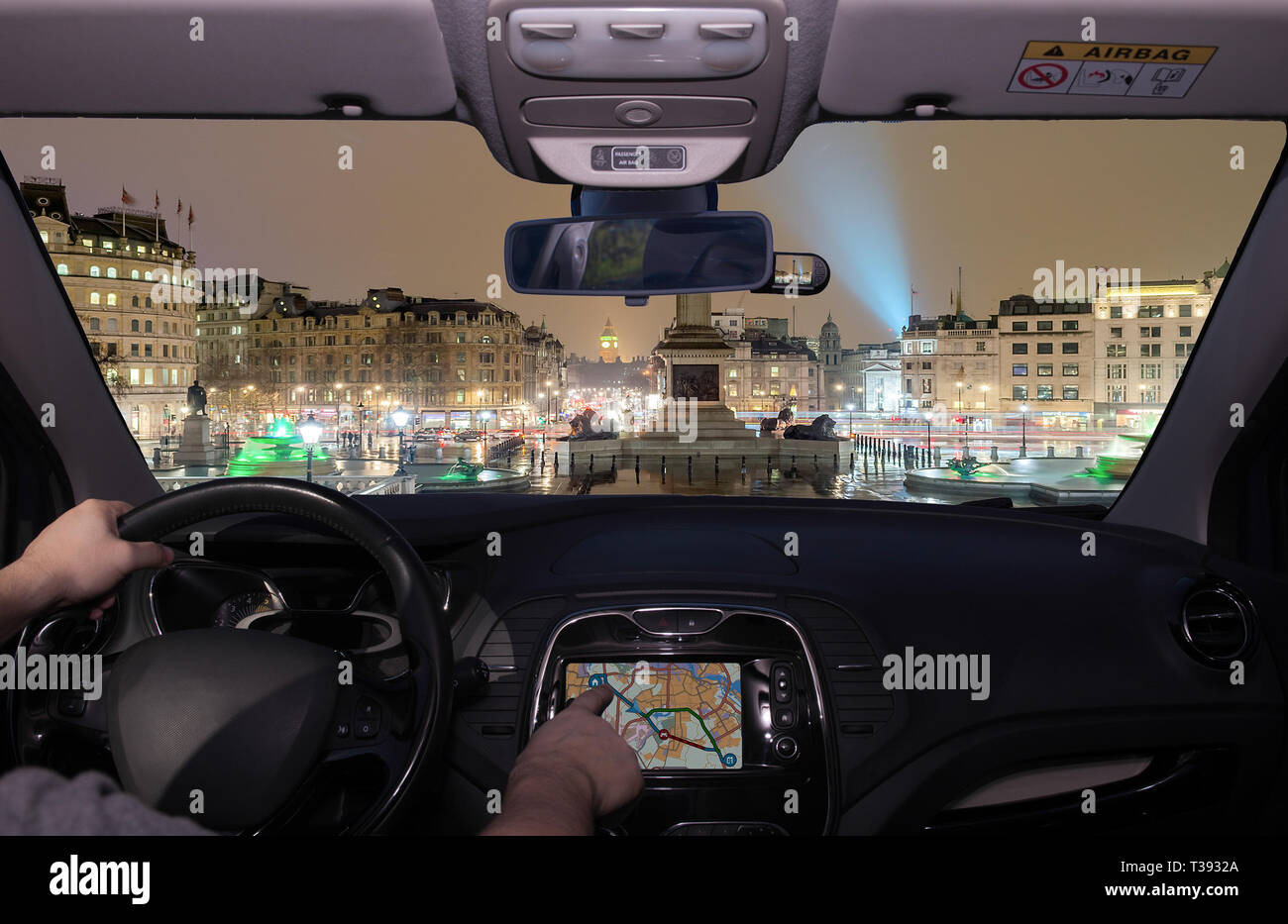 La conduite d'une voiture tout en utilisant l'écran tactile d'un système de navigation GPS vers Trafalgar Square de nuit avec le Big Ben sur l'arrière-plan, London, UK Banque D'Images