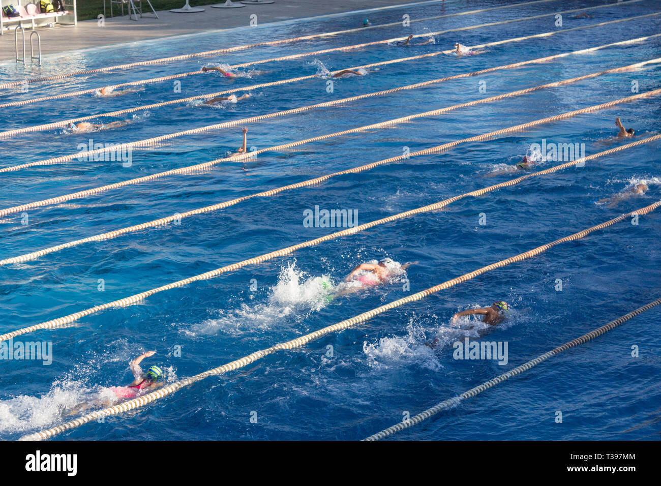 Les jeunes nageurs dans la piscine extérieure en freestyle course. Concept de vie et de remise en forme avec des enfants. Banque D'Images