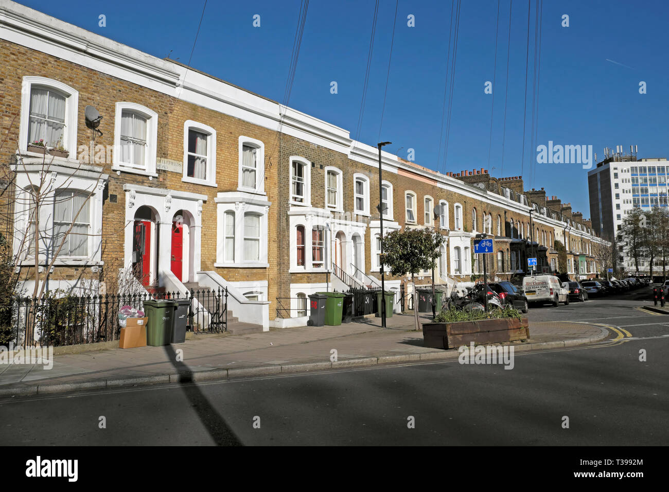 Rangée d'habitations mitoyennes sur Bellefirelds à Brixton Road avec des voitures en stationnement et des poubelles à l'extérieur des maisons, dans le sud de Londres Angleterre Royaume-uni KATHY DEWITT Banque D'Images