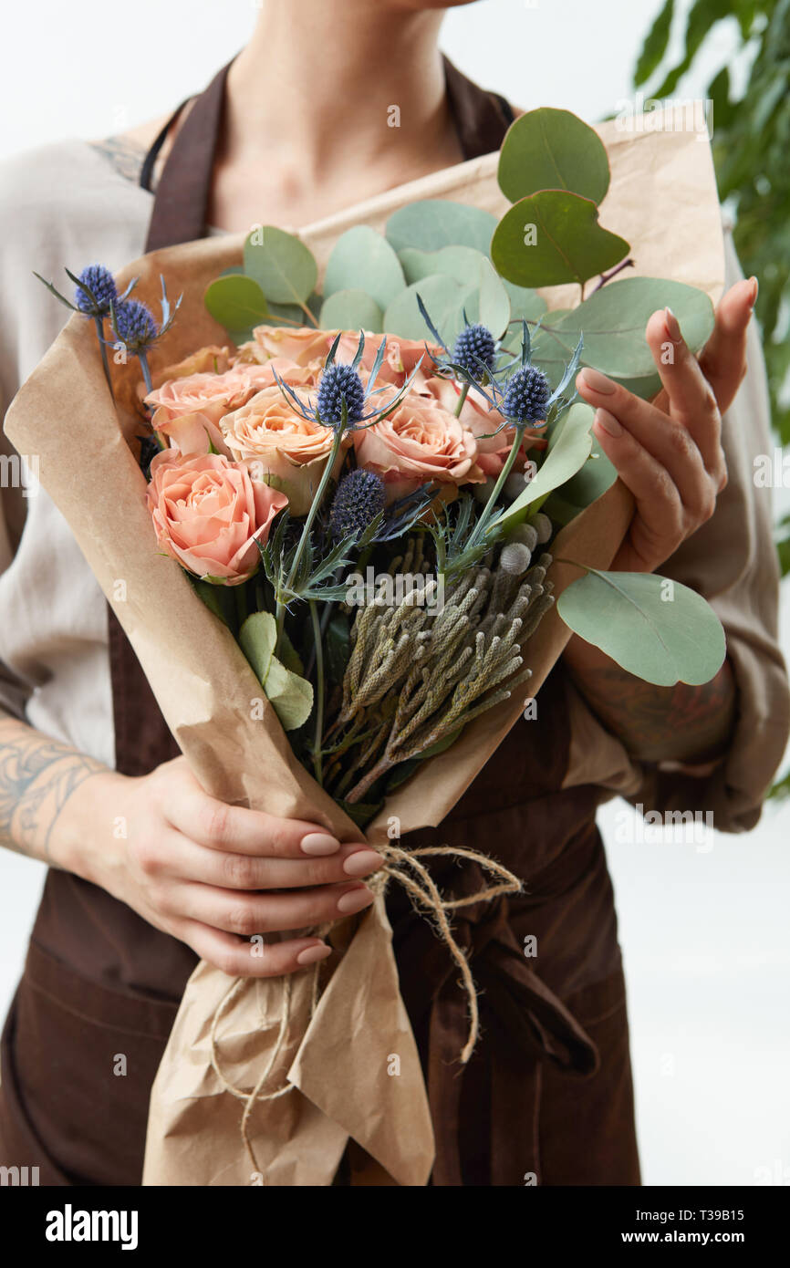 Incroyable frais fleurs bouquet dans les mains d'une femme avec tatouage  sur un fond blanc. Carte de vœux Photo Stock - Alamy