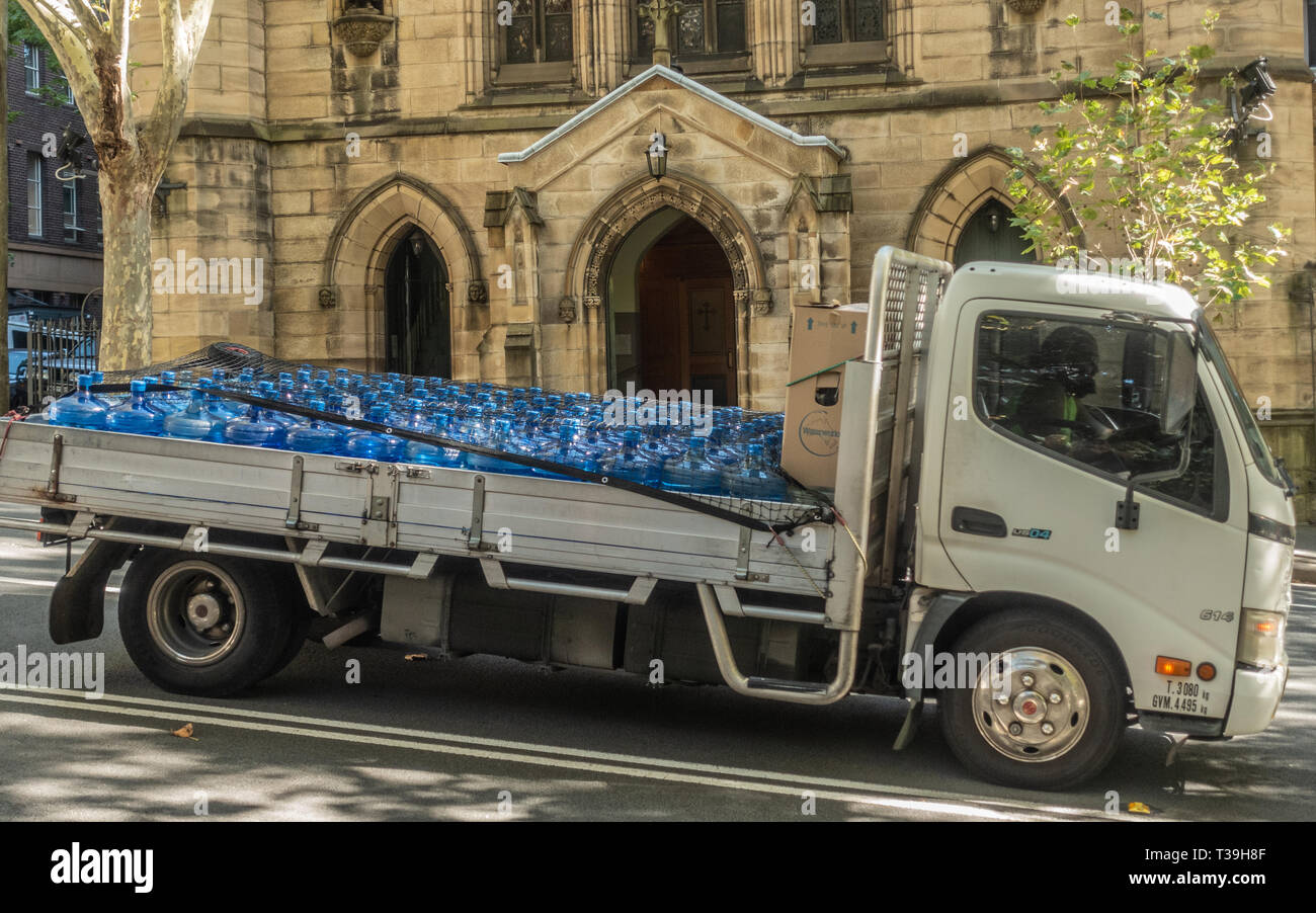 Sydney, Australie - 12 Février 2019 : à plat blanc van transporte un chargement complet de bouteilles d'eau potable grand bleu. La façade jaune est de retour de Saint P Banque D'Images