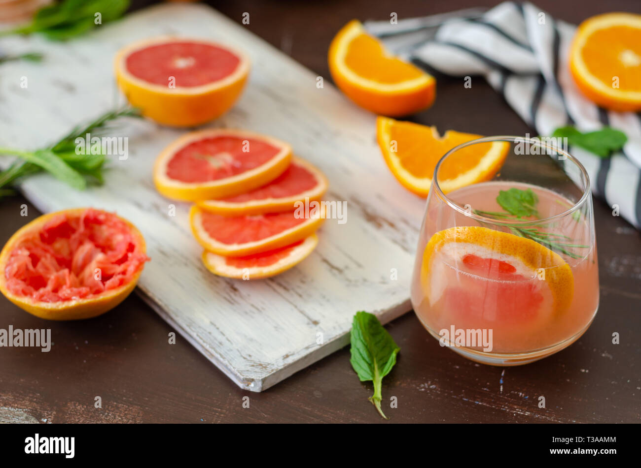 Le pamplemousse et les oranges mûres avec du jus de pamplemousse sur table en bois Banque D'Images