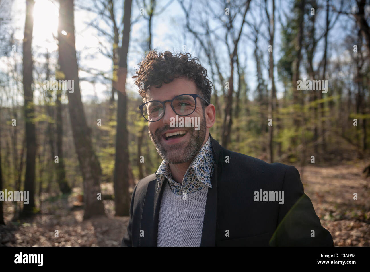 Un homme, 30-34 ans, souriant franchement à l'appareil photo, portant des lunettes. dans le parc ou la forêt, les loisirs en plein air. Banque D'Images