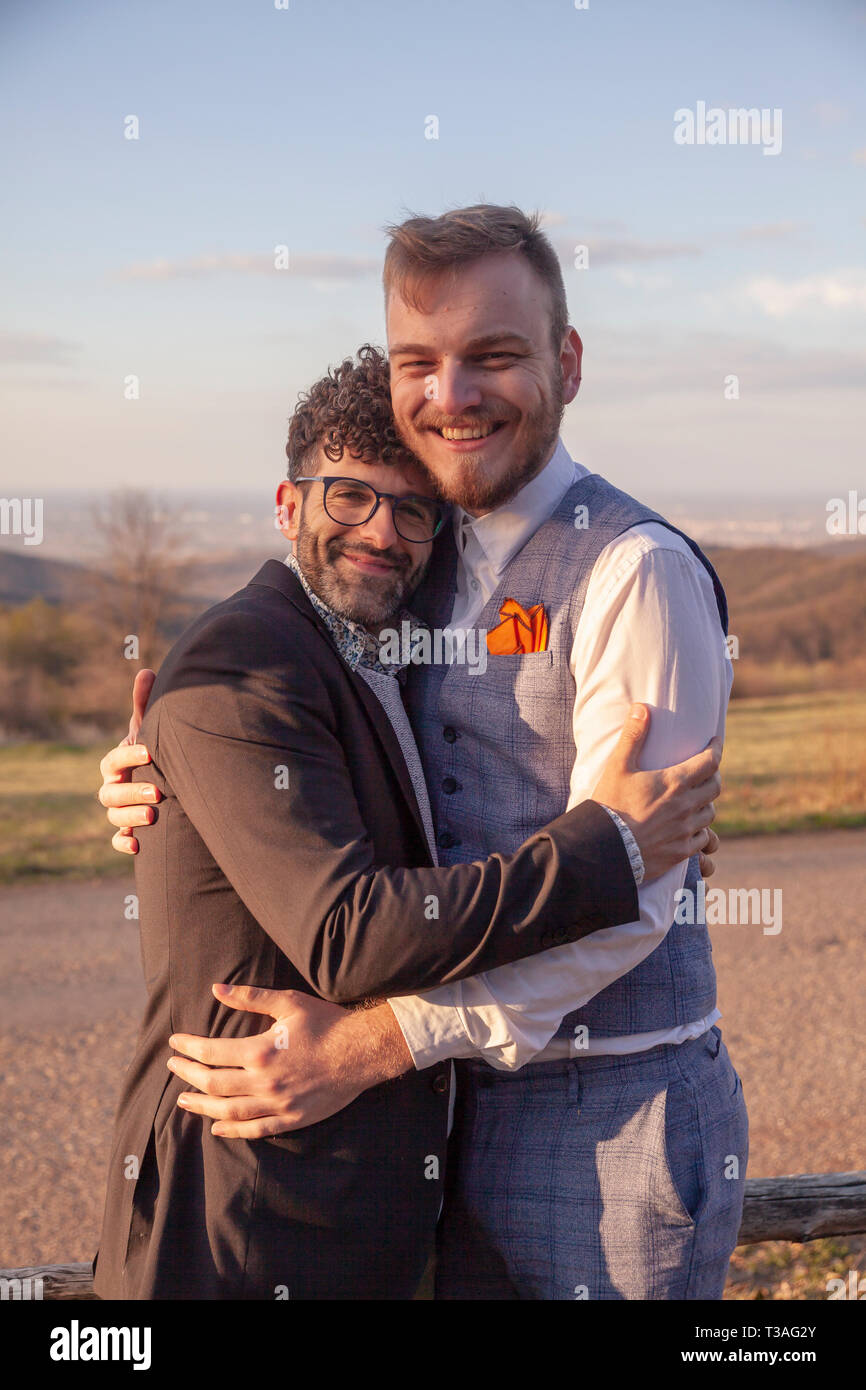 Deux homme, souriant et heureux gay couple hugging outdoors dans la nature. Banque D'Images