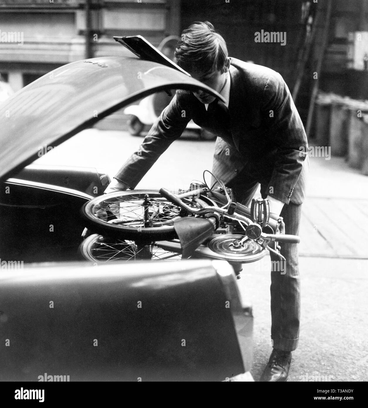 Motorist mettre le vélo dans le coffre, 1965 Banque D'Images