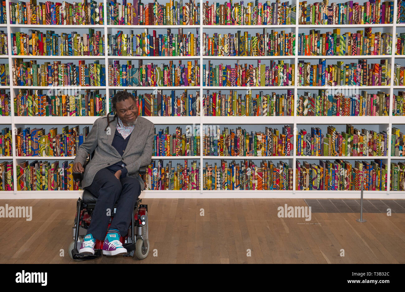 Londres, Royaume-Uni. 8 avril, 2019. Artiste Yinka Shonibare, CBE, au Tate Modern aux côtés de son installation La British Library, le dernier dessin d'être acquis par Tate.La British Library est une installation in-situ avec une plate-forme numérique pour les visiteurs à se joindre à la discussion. Une célébration de la diversité de la population britannique qu'il contient 6 328 livres reliés en néerlandais 'Imprimer' de cire, un tissu typiquement utilisé par l'artiste dans son travail. Credit : Malcolm Park/Alamy Live News. Banque D'Images