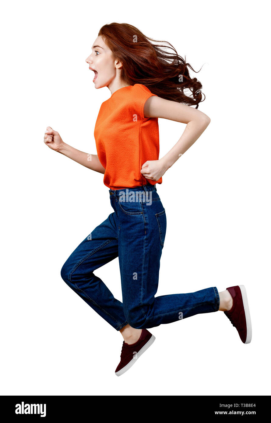 Longueur totale de gingembre en femme heureuse shirt et jeans de saut. Banque D'Images