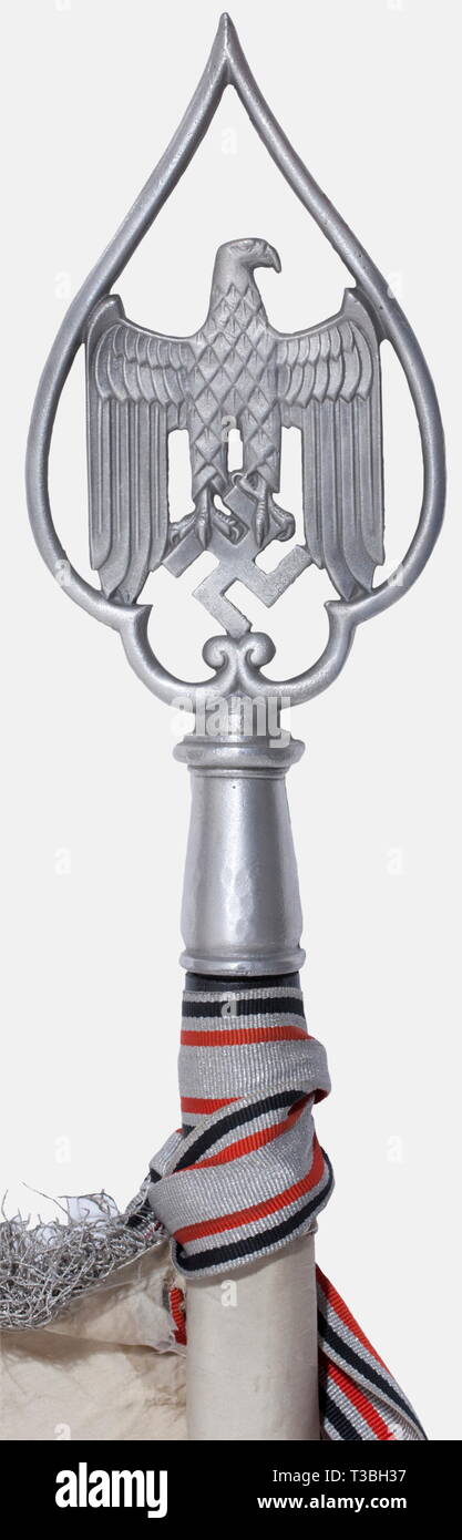 Une norme pour un bataillon d'infanterie, avec le drapeau de soie blanche banderoler avec frange d'argent sur trois côtés. Des deux côtés d'une armée noire brodée blanche avec ses plumes mis en valeur de Brown. Bec et serres rendues en broderie d'or, posée sur un champ de soie de couleur crème, entouré d'une feuille de chêne brodées d'argent couronne sur une croix de fer. Une croix gammée appliquée dans chacun des coins. Dimensions ca. 125 x 125 cm. De Banderole tissu d'aluminium avec un noir/blanc/rouge s'entremêlent, complet avec les deux fermoirs, affichage de '16. März 1935', et '16. März 1936, No-Exclusive Editorial-Use-Utilisation | seule Banque D'Images