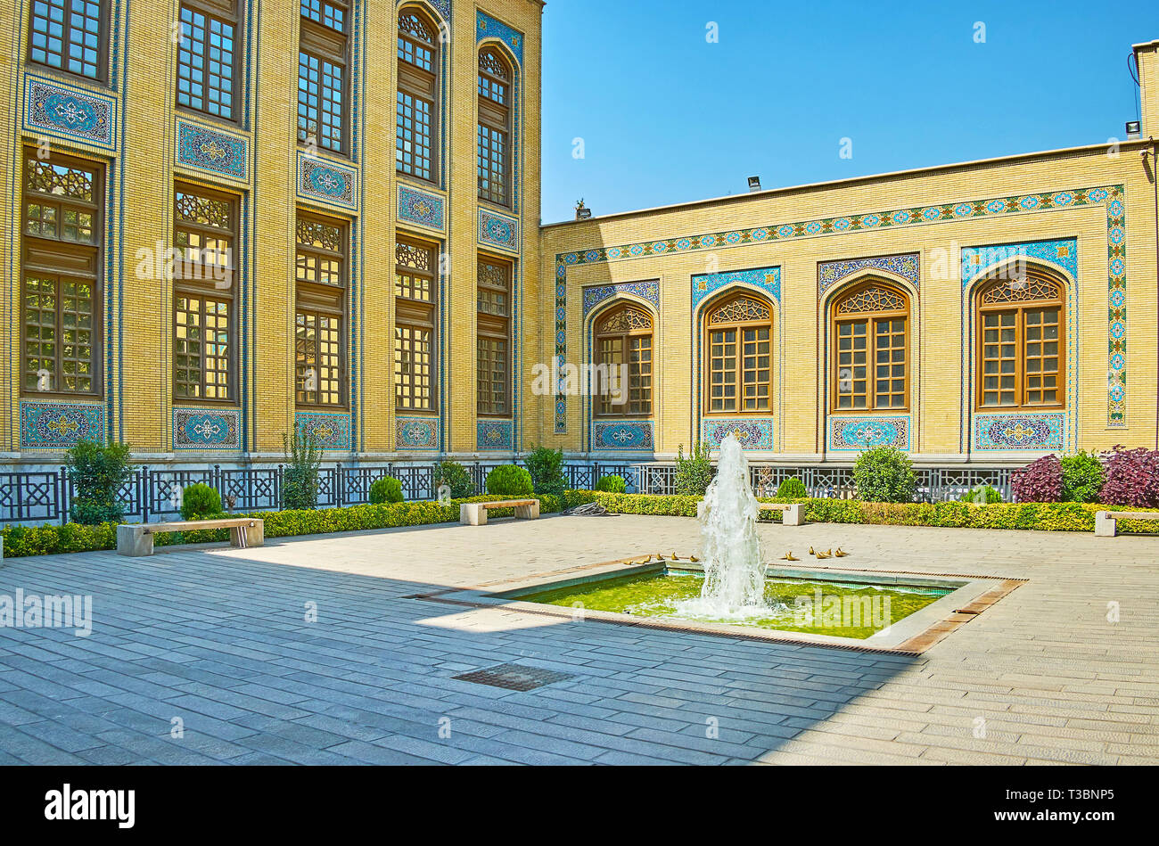 La petite fontaine en face du bâtiment historique du musée et de la bibliothèque Malek, Bagh-e Melli trimestre, Téhéran, Iran. Banque D'Images