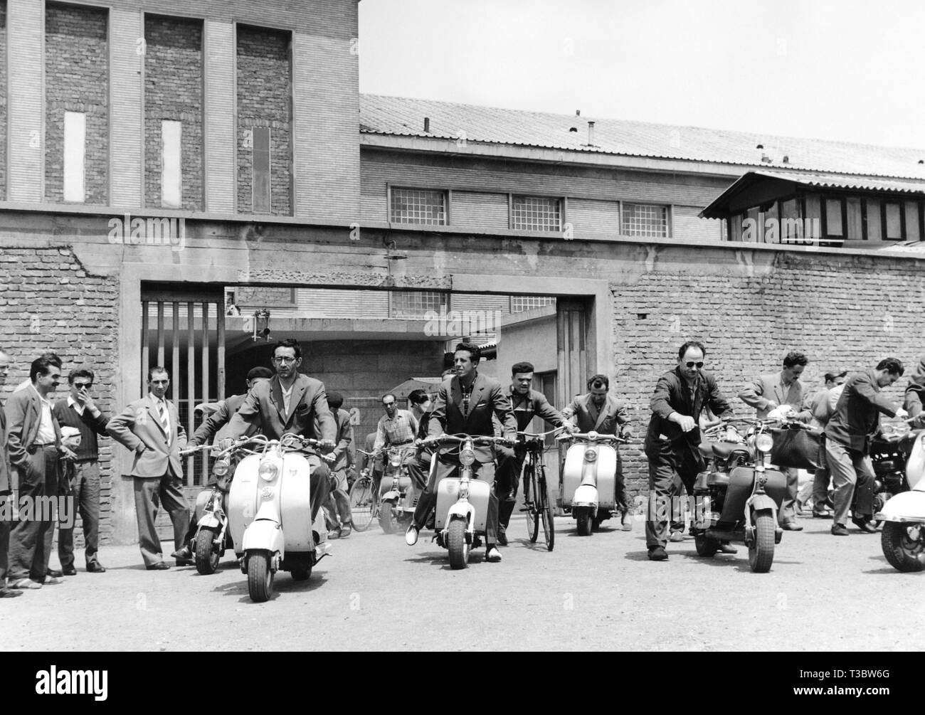 Sortir les travailleurs d'une usine avec des scooters, 1958 Banque D'Images