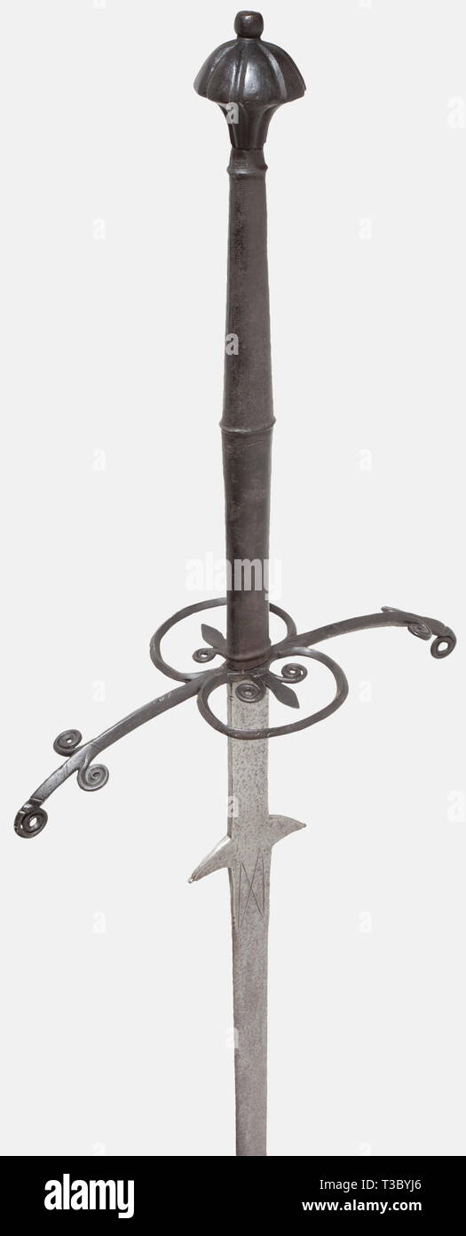 Une grande épée à deux mains, Wolfgang Stantler II, Passau, vers 1580, Massive arme à double lame avec un ricasso et deux pattes en forme de Fluke. Le loup de Passau mark gravé sur un côté, et la moitié d'un orb gravé sur l'autre. Vestiges des incrustations en laiton avec lignes décoratives en forme de croix de Saint Andrews gravé au-dessus eux, en conservant des traces infimes de l'original incrustations en laiton. Quillons légèrement courbé avec encoches décoratif et ornemental laminées avec Split et de faîtage. Anneau de protection sur les deux côtés avec insertion de décoration fleur de lys. Avec poignée, Additional-Rights Clearance-Info-wel-Not-Available Banque D'Images