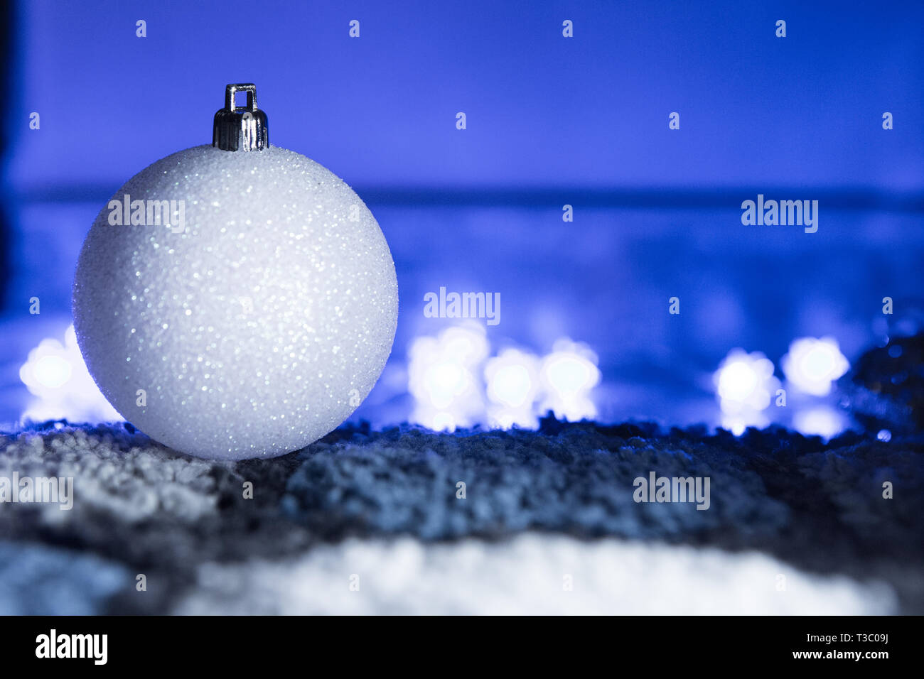 Bal de Noël blanc brillant en bleu la lumière ambiante Banque D'Images