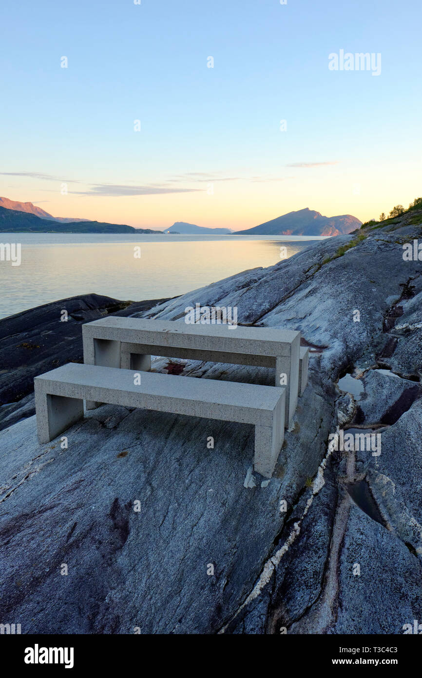 Une table de pique-nique à l'Hellåga Sjonafjord sur une aire de repos le long de la route panoramique nationale Helgelandskysten dans Nordland Norvège - crépuscule paysage fjord Banque D'Images