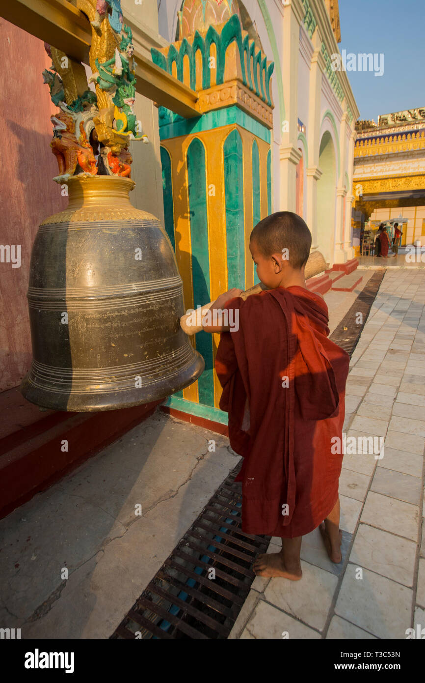 Moine Bouddhiste Novice frappant une cloche à la pleine lune du Vesak festival pour célébrer l'anniversaire de Bouddha à la pagode Shwe Yin Maw, près de Thazi, Myan Banque D'Images