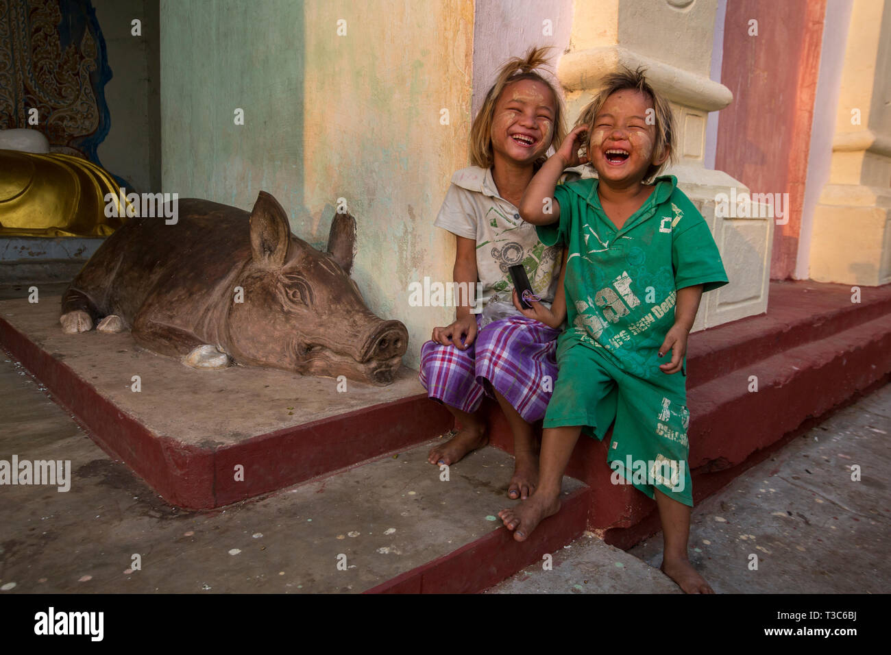 Cochon de pierre et les enfants rire à la pleine lune du Vesak festival pour célébrer l'anniversaire de Bouddha à la pagode Shwe Yin Maw, près de Thazi, le Myanmar ( Banque D'Images