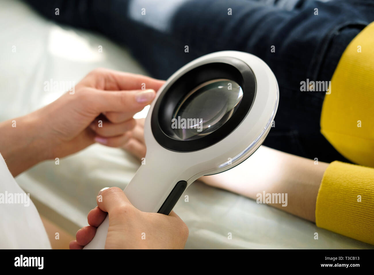 Dermatologue à l'aide d'une loupe professionnelle tout en faisant l'examen de la peau, contrôle sur la main. Les taupes bénigne Dermatologist examining birthmarks un Banque D'Images