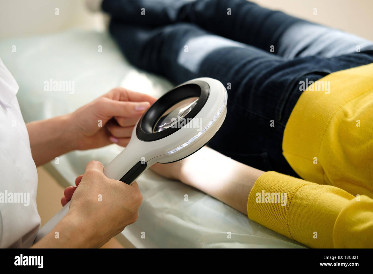 Dermatologue à l'aide d'une loupe professionnelle tout en faisant l'examen de la peau, contrôle sur la main. Les taupes bénigne Dermatologist examining birthmarks un Banque D'Images
