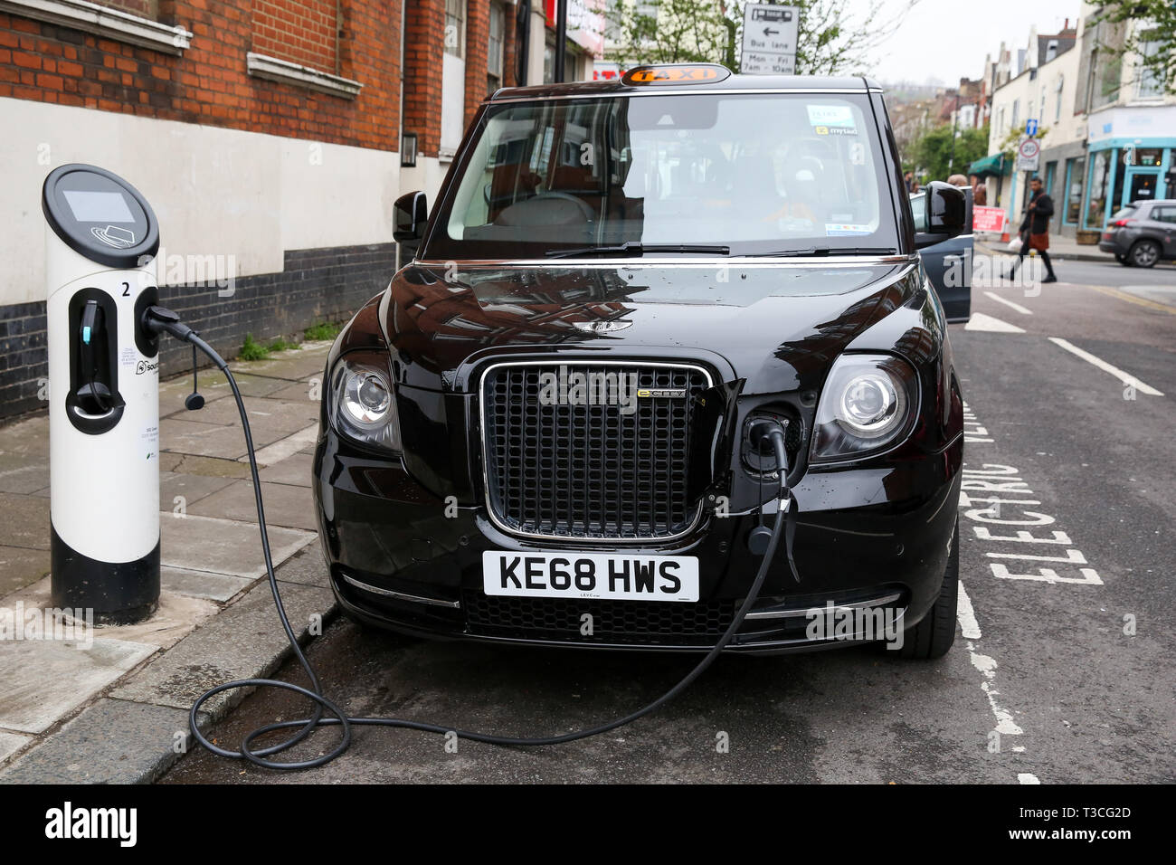 Un taxi londonien noir est vu en utilisant la voiture électrique point de recharge à Londres. Pour améliorer la qualité de l'air, une zone d'émission ultra faible (ULEZ) qui est entrée en vigueur le lundi 8 avril 2019, exploite maintenant 24 heures par jour, 7 jours par semaine, dans la même zone de centre de Londres comme la Congestion Charge. Les conducteurs doivent respecter les normes d'émissions ULEZ ou avoir à payer une redevance quotidienne, en plus de Congestion Charge de conduire à l'intérieur de la zone, des taxis qui sont exemptés de l'Ultra Low Emission Zone. Banque D'Images