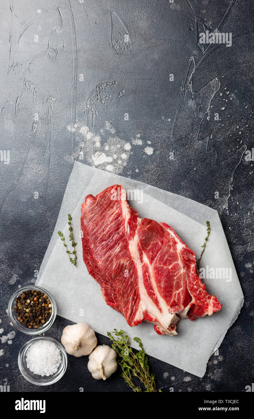 Frais Macro coupe de bœuf viande sur fond gris avec des fines herbes, sel et poivre. Espace libre pour le texte. Vue d'en haut. Concept d'aliments frais Banque D'Images