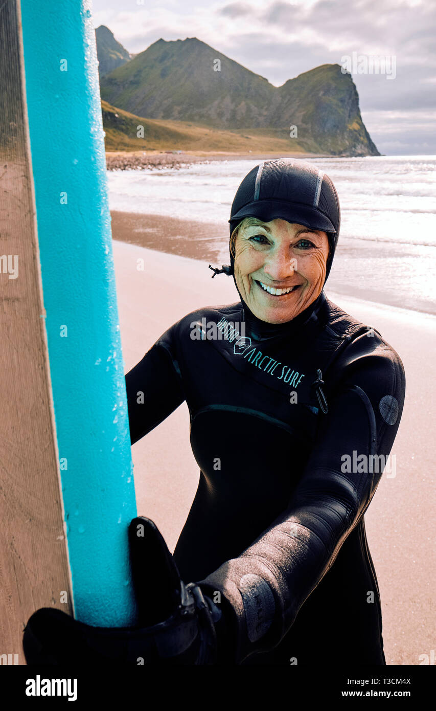 Une bonne femme d'âge moyen de la combinaison de surfeur à Unstad mactre de l'économie la plus nord de l'Arctique Surf resort plage de Unstad Lofoten en Norvège Banque D'Images