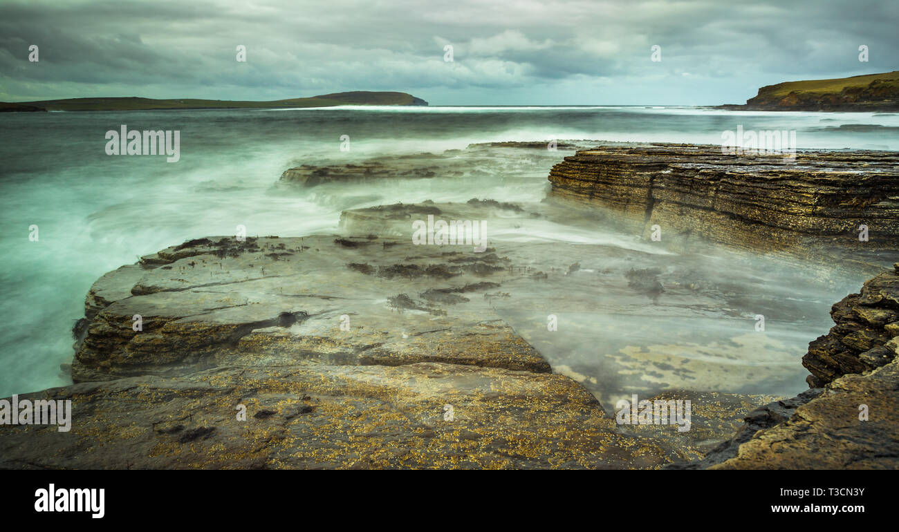 Une longue exposition de droit de la mer se brisant sur les rochers au milieu Howe, Rousay, Orkney Islands Banque D'Images