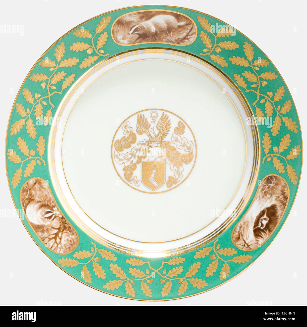 Hermann Göring, une assiette dessert par l'usine Sèvres à partir du service qui lui a été présenté par l'usine à l'occasion de son 50e anniversaire le 12 janvier 1943. Blanc, porcelaine émaillée, dans le centre de golden, jaunâtre, encadrées de grandes armoiries de la famille Göring, émaillés vert avec des frontières, de l'or riche-découpe décoration feuille de chêne et golden rim ainsi que trois médaillons avec des représentations de blaireaux. Sur le fond la marque du fabricant en vert sous glaçure Sèvres 1943 et le dévouement inscription en or overglaze Reichsmarschall des Grossdeutschen 'Dem Re, Editorial-Use-seulement Banque D'Images