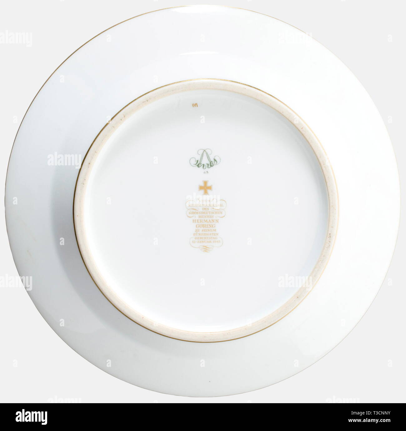 Hermann Gpring, une assiette dessert par l'usine Sèvres à partir du service qui lui a été présenté par l'usine à l'occasion de son 50e anniversaire le 12 janvier 1943. Blanc, porcelaine émaillée, dans le centre de golden, jaunâtre, encadrées de grandes armoiries de la famille Göring, vert, avec des frontières, de l'or riche-découpe décoration feuille de chêne et golden rim ainsi que trois médaillons peints à la main avec les représentations de la martre. Sur le fond la marque du fabricant en vert sous glaçure Sèvres 1943 et le dévouement inscription en or overglaze 'Dem des Grossdeutsc Editorial-Use le Reichsmarschall, seule Banque D'Images