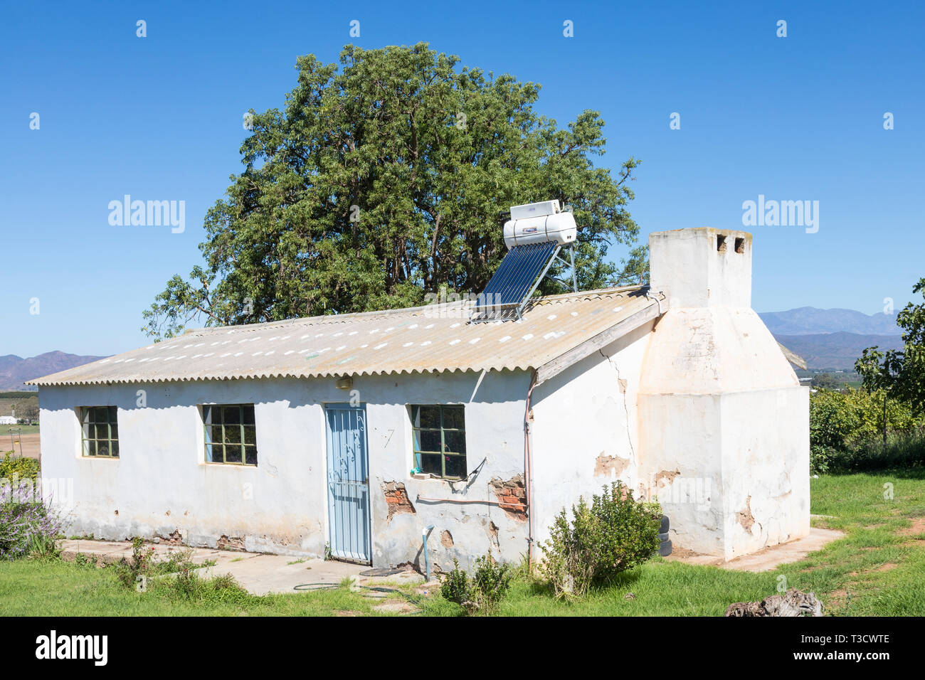 Cottage avec petits ouvriers agricoles chauffe-eau solaires montés sur le toit geyser et panneau photovoltaïque, une ressource naturelle, renouvelable et durable, la puissance, l'énergie, il Banque D'Images