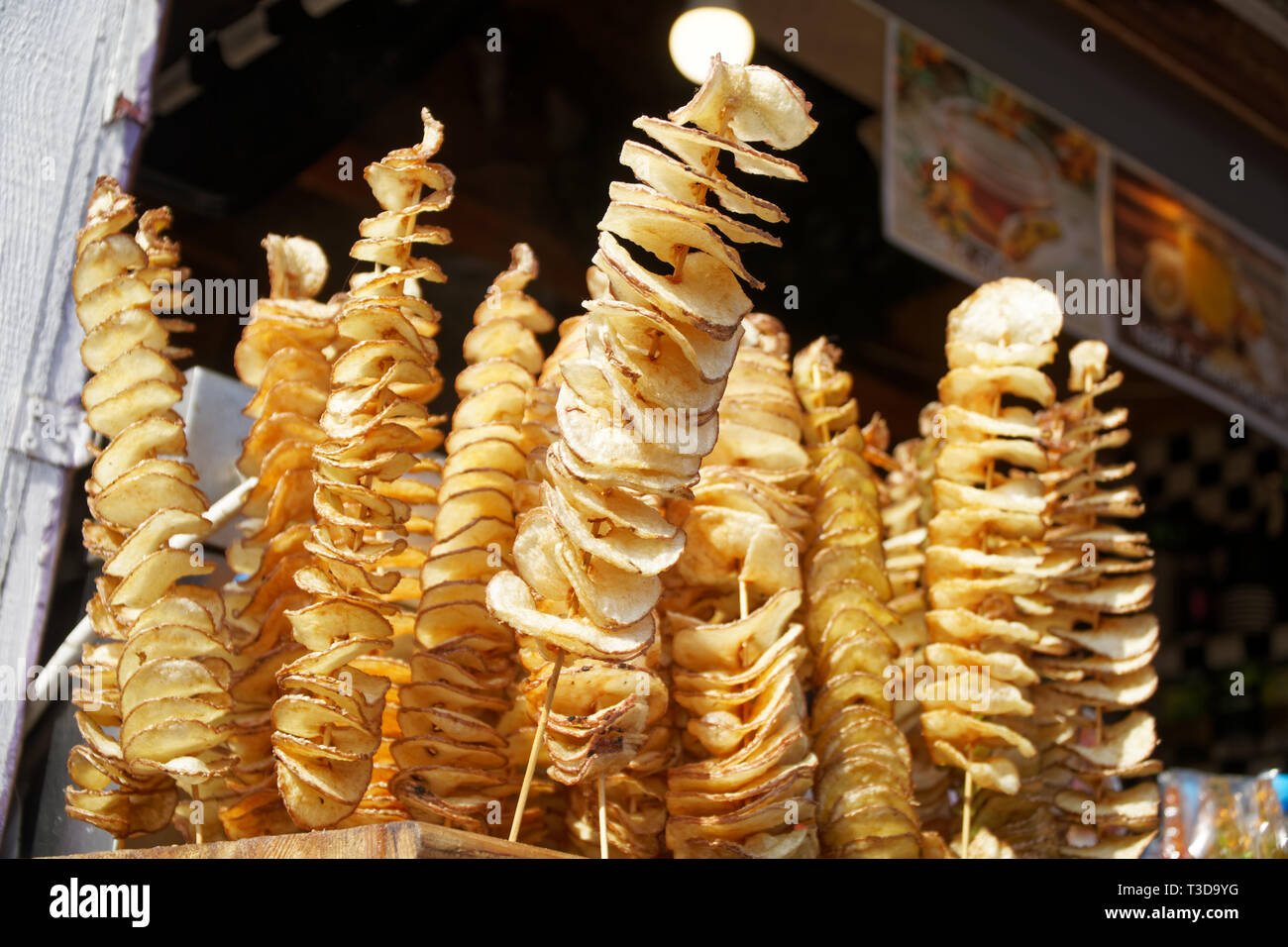 Croustilles de pommes de terre frites sur stick, pommes frites, en spirale sur des bâtonnets de bois, en spirale. Vente de produits alimentaires sur le marché. L'alimentation de rue frit malsain Banque D'Images