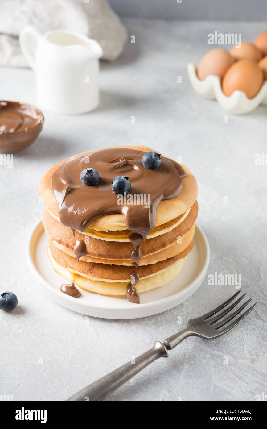 Pile de crêpes faites maison sucré avec du chocolat et de bleuet sur tableau blanc. Close up. Banque D'Images