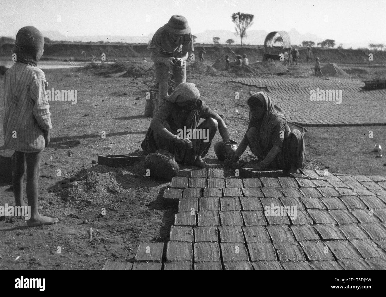 L'homme et la femme des briques à la main en Inde Britannique 1945 Banque D'Images