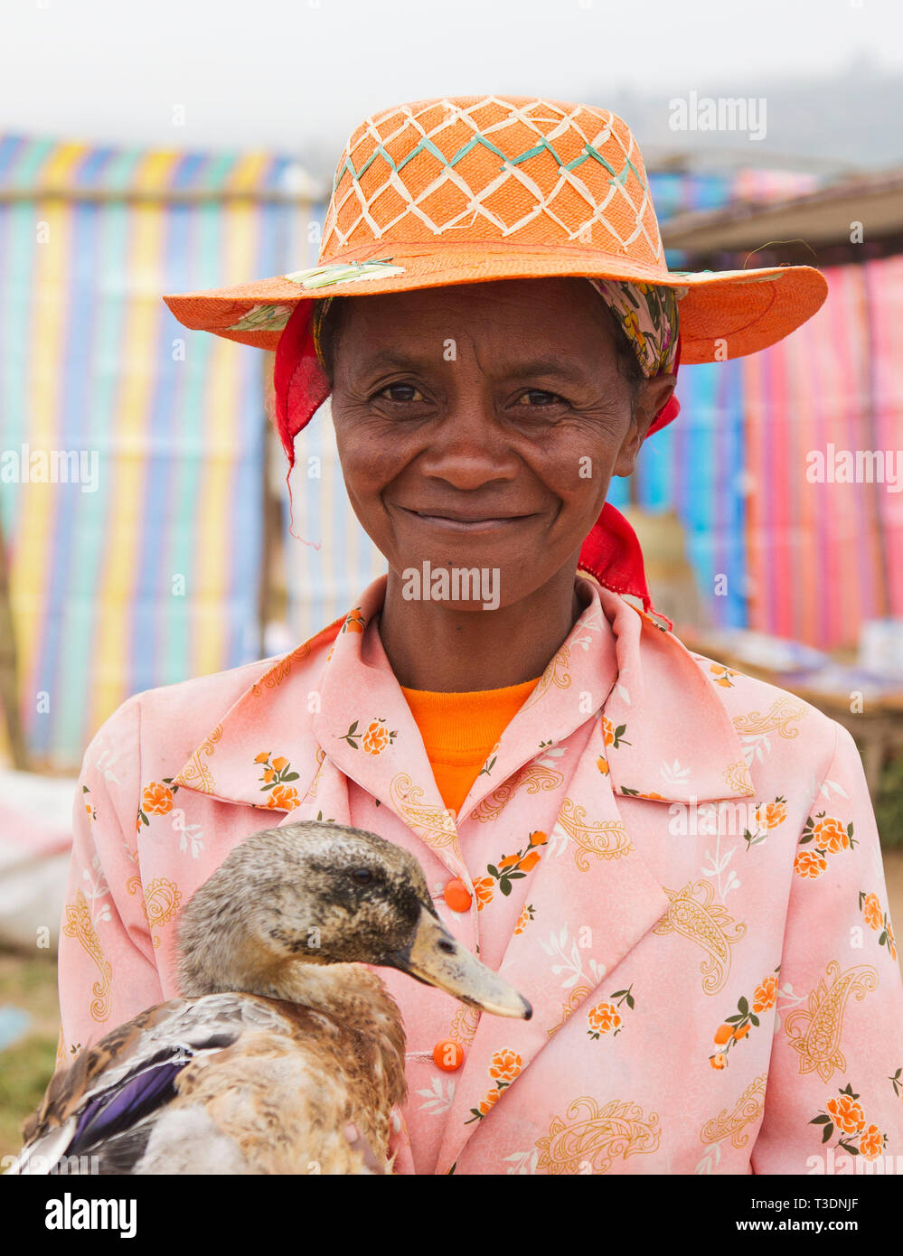 Portrait de femme malgache avec chapeau de paille traditionnel et tenant un canard à un marché de fermiers,montagne,Madagascar,Afrique Banque D'Images