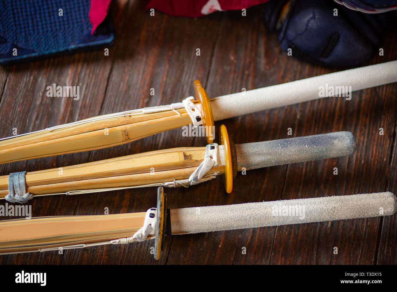 Les sabres de bambou close-up. Le kendo gants, casque et l'épée de bambou sur une surface en bois. Armure de kendo. Banque D'Images